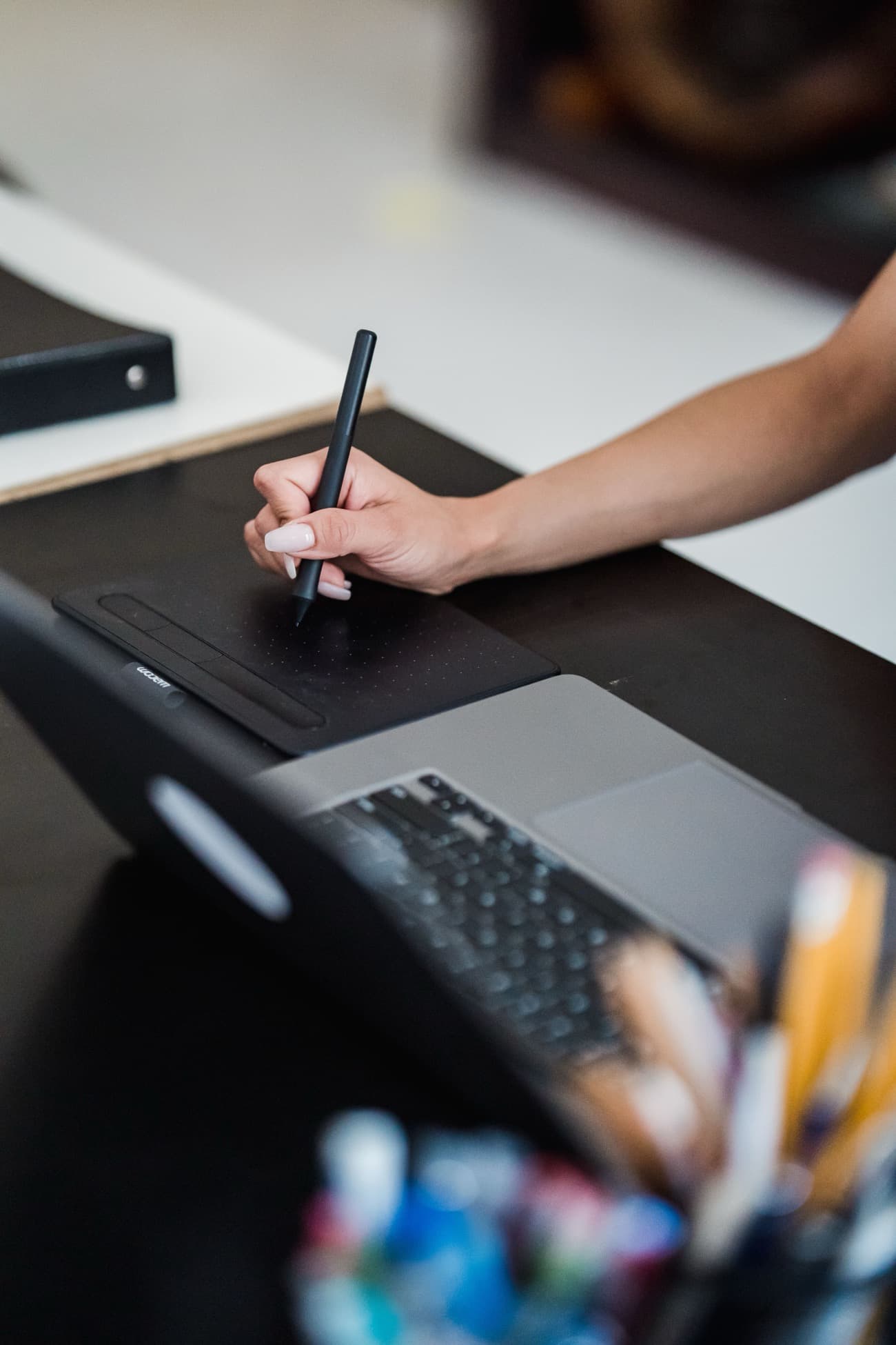 Diseñadora trabajando con tableta gráfica y laptop